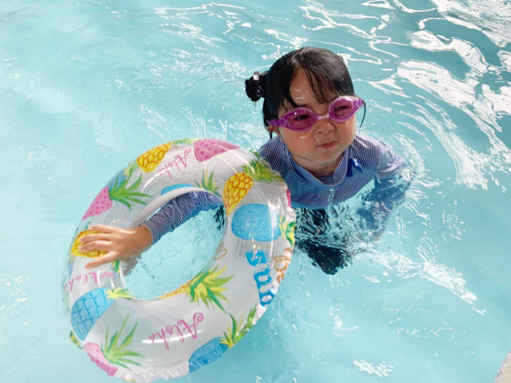 浮き輪をもってプールで遊ぶ女の子